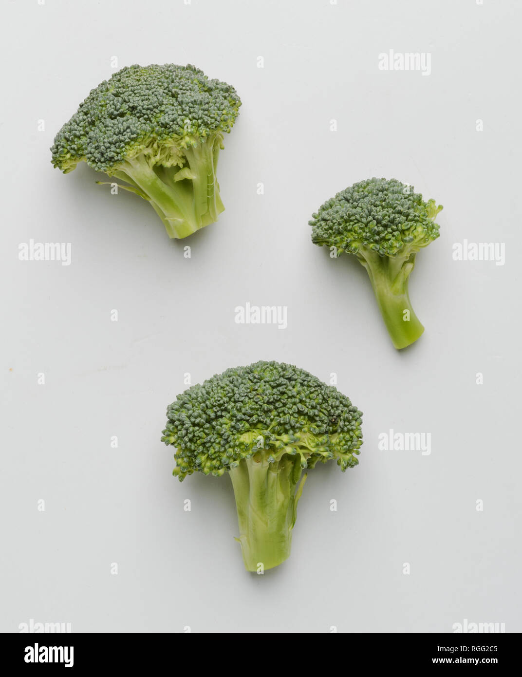 Alcune cime di broccoli su bianco Foto Stock