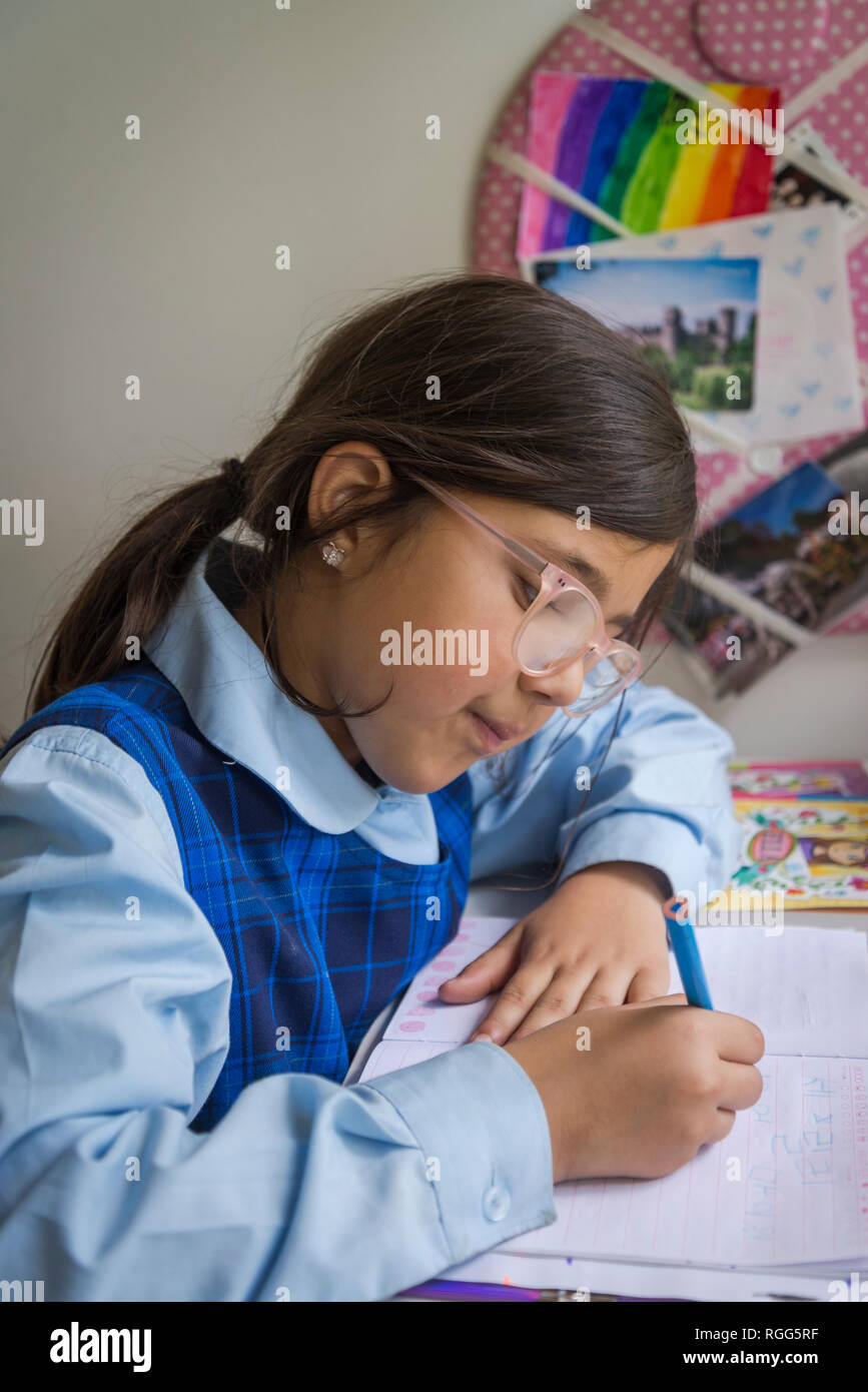 8 anno vecchia ragazza iscritto alla sua scrivania Foto Stock