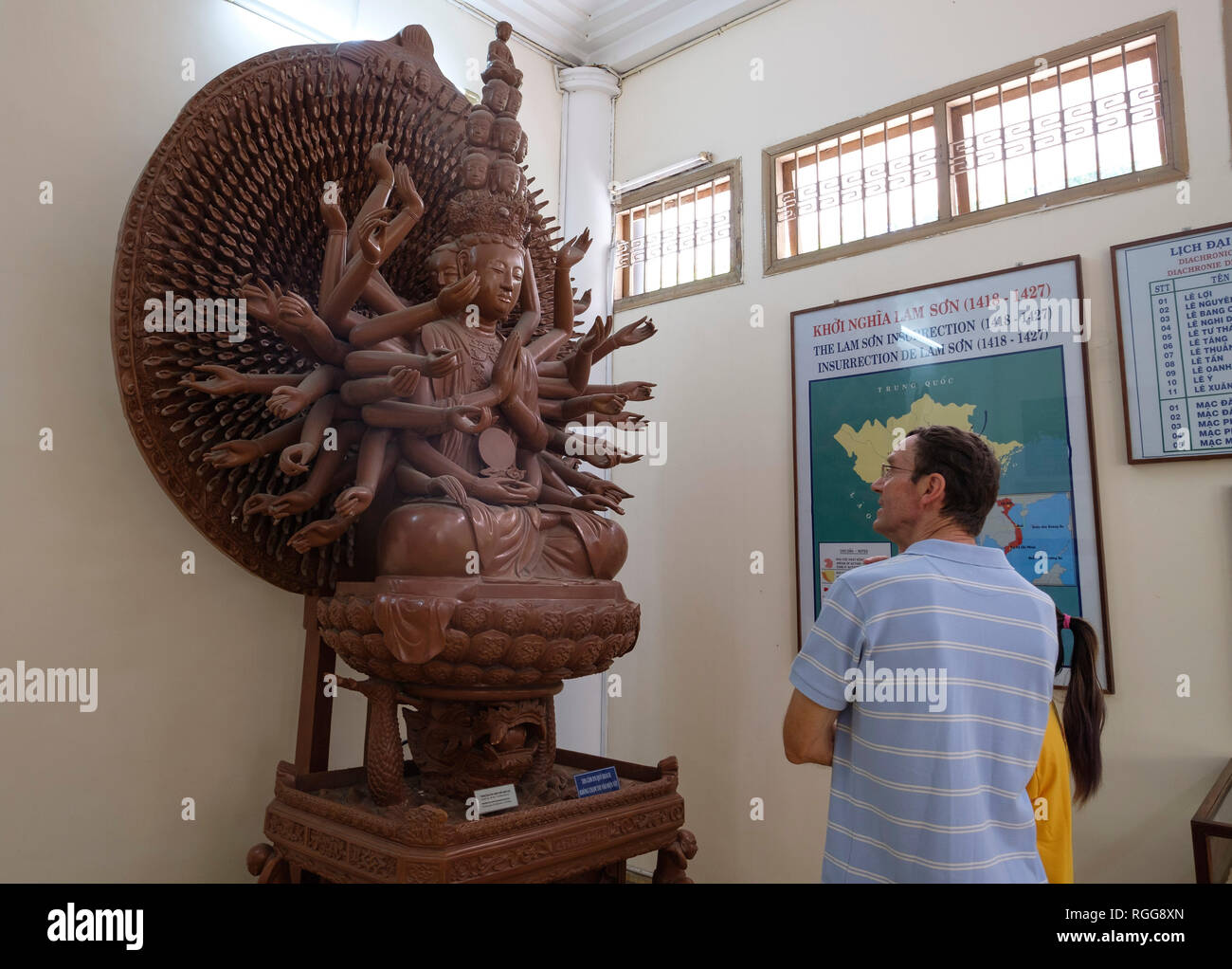 I turisti in cerca di un Indù scultura in legno presso il Museo di Storia di Ho Chi Minh, Vietnam Asia Foto Stock