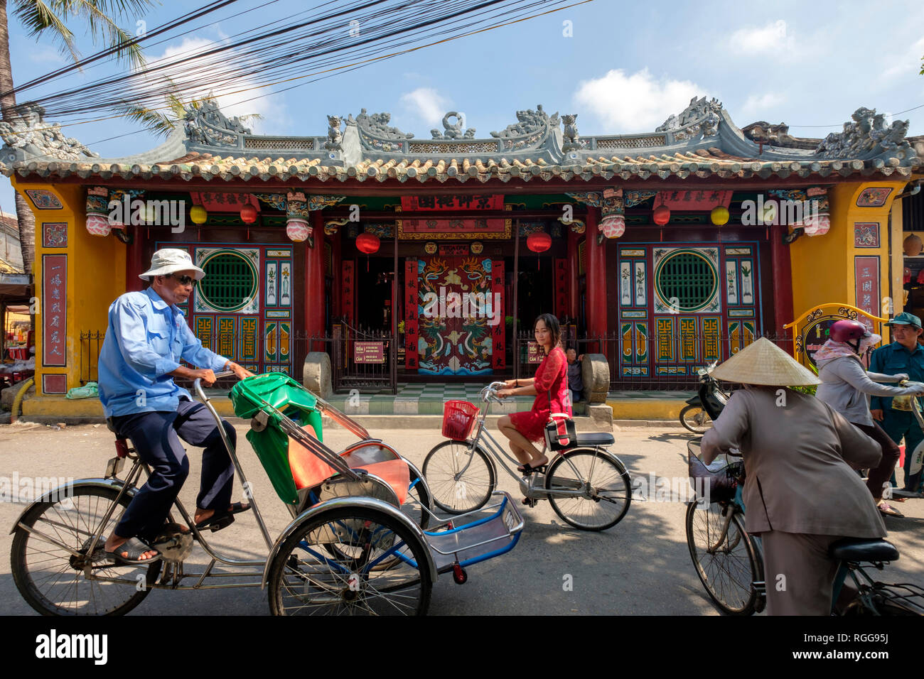 Gente in bicicletta nella parte anteriore della Quan Cong tempio aka Chua Ong nella pagoda Hoi An, Vietnam Foto Stock