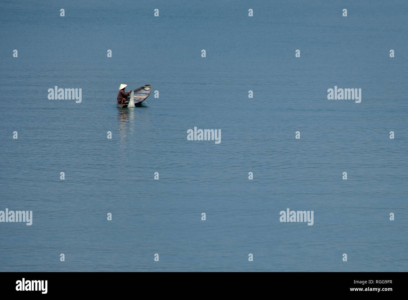 Pescatore vietnamita su una piccola barca da pesca sul Fiume Perfume in tinta, Vietnam, Asia Foto Stock