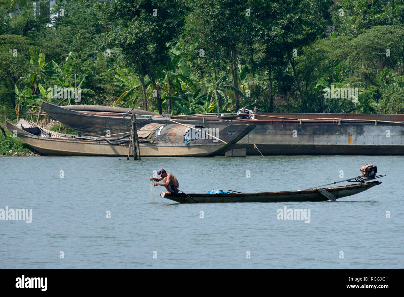 Pescatore vietnamita su una piccola barca da pesca sul Fiume Perfume in tinta, Vietnam, Asia Foto Stock