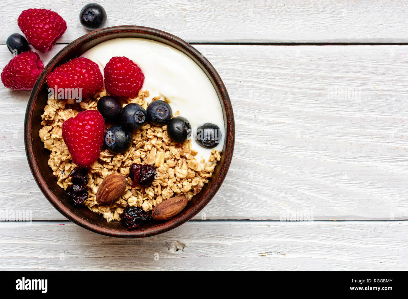 In Casa Lo Yogurt Greco Con Cereali E Frutti Di Bosco Freschi In Una Ciotola Su Bianco Tavolo In Legno Vista Superiore Foto Stock Alamy