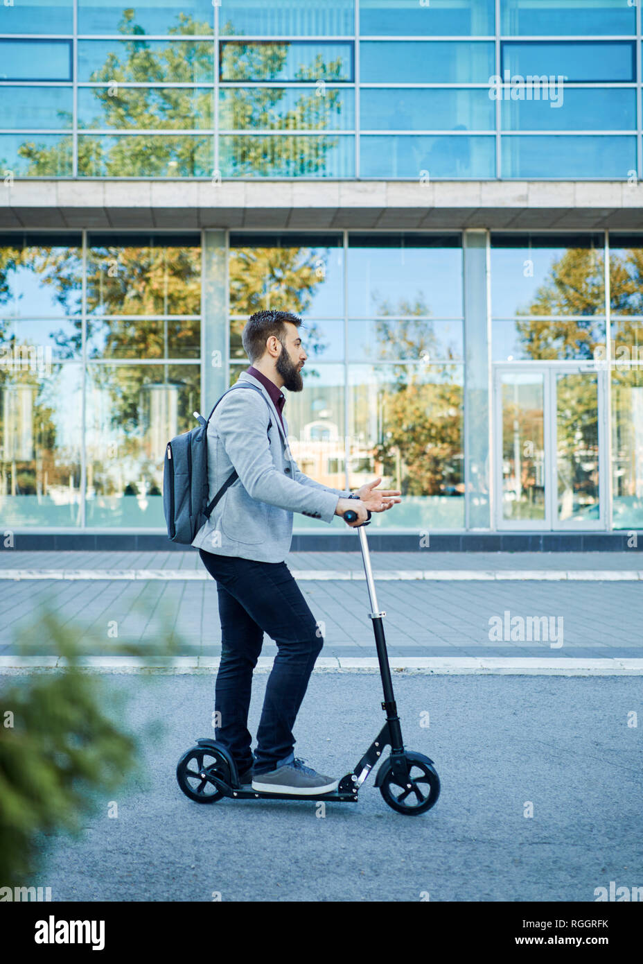 Imprenditore con uno scooter sul modo in Foto Stock