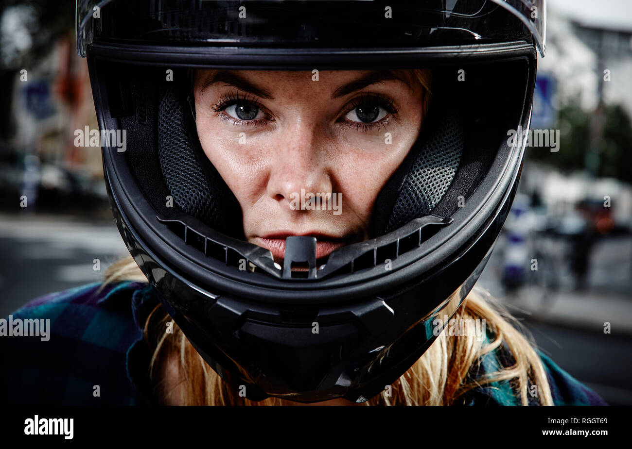 Ritratto di fiducioso giovane donna che indossa il casco del motociclo Foto Stock