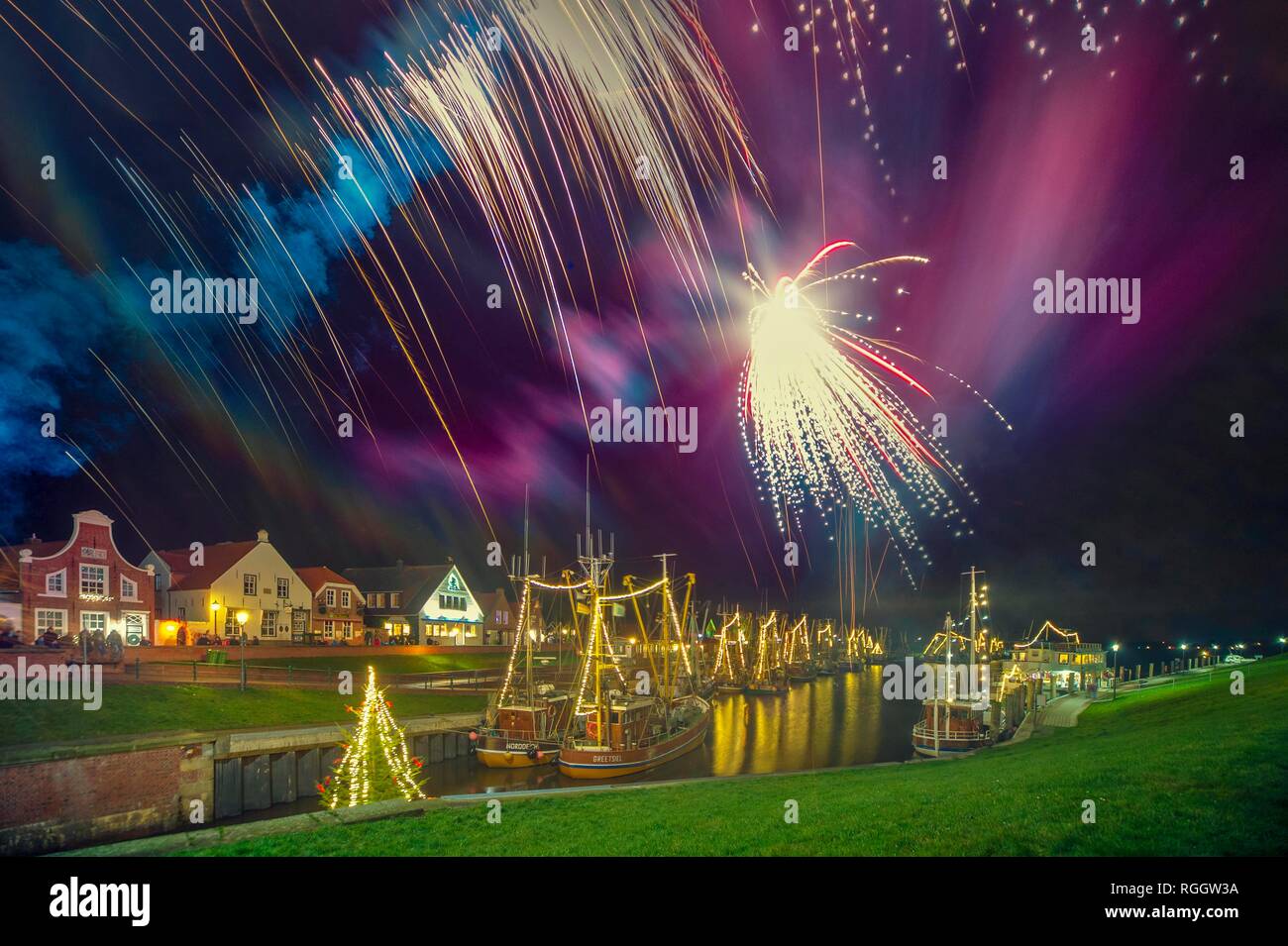 La Vigilia di Capodanno, fuochi d'artificio in porto, Greetsiel, Krummhörn, Bassa Sassonia, Germania Foto Stock