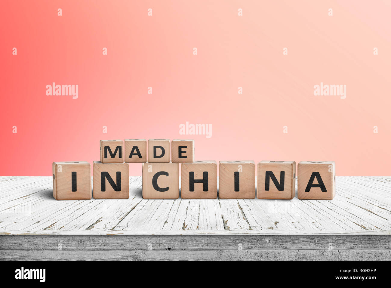 Fabbricato in Cina segno su una scrivania di legno con una parete rossa in background Foto Stock Fabbricato in Cina segno su una scrivania di legno con una parete rossa in background Foto Stock