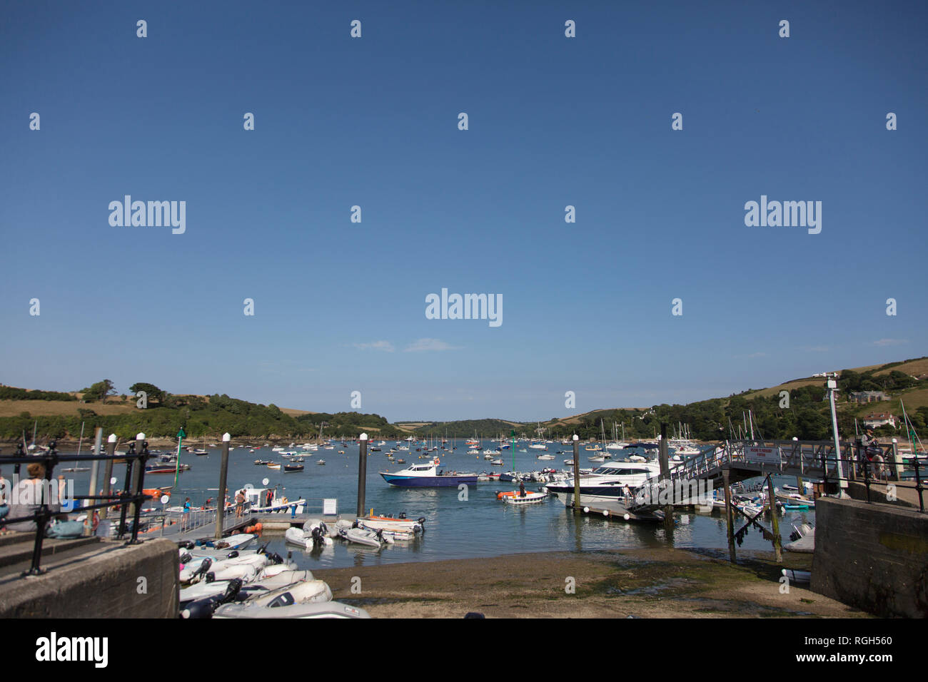 Salcombe estuario Harbour, barche ormeggiate nel estuario su una soleggiata giornata d'estate, con acque calme e verdi colline sullo sfondo di questa località turistica Foto Stock