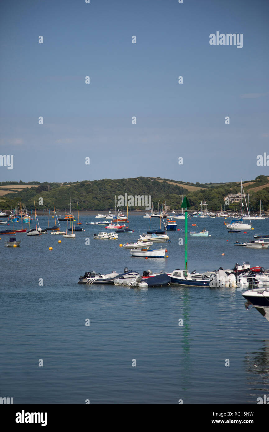 Salcombe estuario Harbour, barche ormeggiate nel estuario su una soleggiata giornata d'estate, con acque calme e verdi colline sullo sfondo di questa località turistica Foto Stock