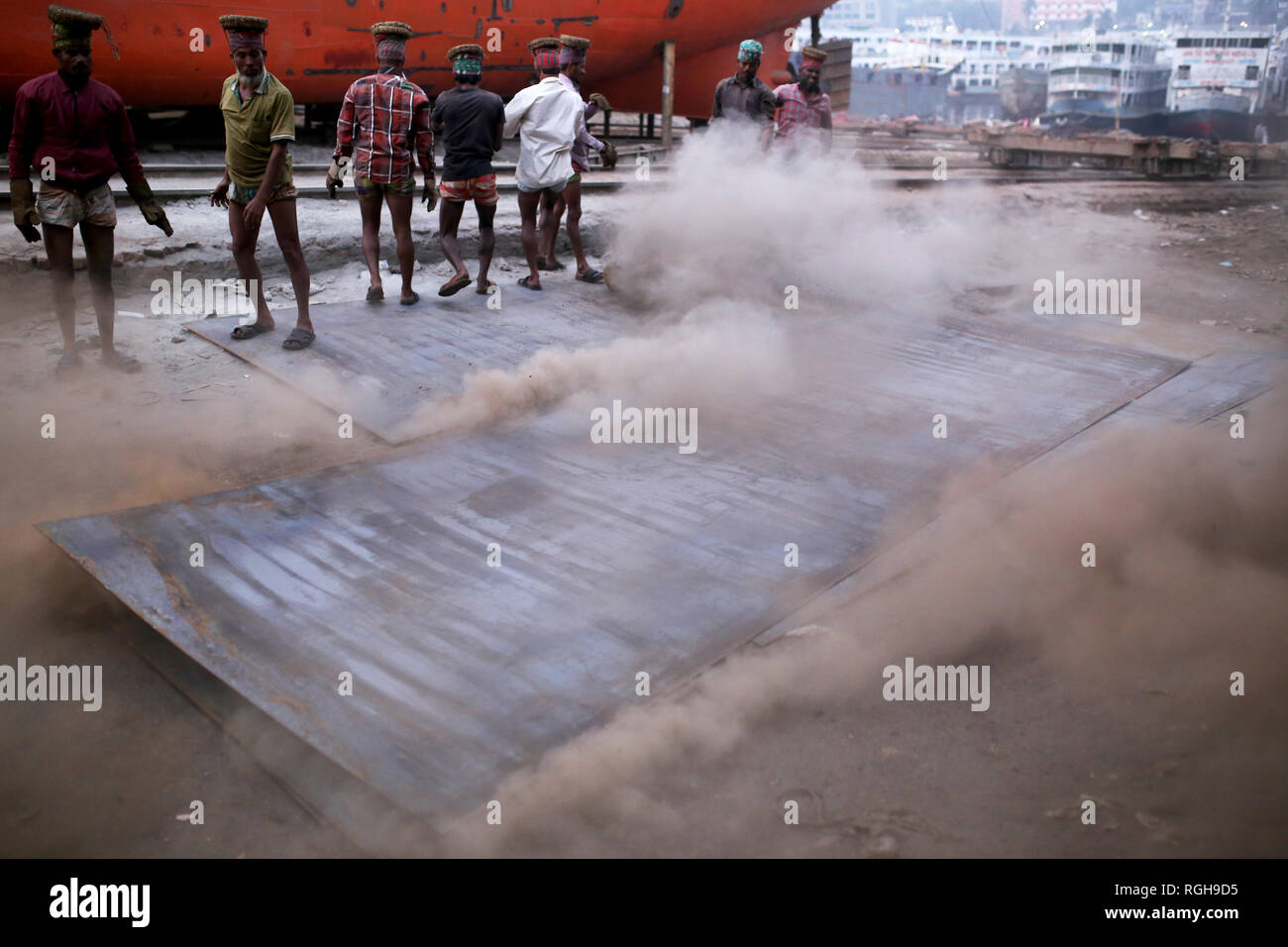 Lavoratori portano una pesante pezzo di lamiera in un cantiere navale a Dhaka, nel Bangladesh il 29 gennaio 2019. Decine di cantieri che occupa 30.96 acri del Buriganga foreshore sono state in funzione per gli ultimi cinquant'anni. Essa è principalmente utilizzata per il fissaggio e la riparazione di navi vecchie, costruire in nuove navi. Fatiche lavori in cantiere senza caschi, la maschera per il viso o scarpe di sicurezza come la loro età da 8 a 80 anni di età. Quasi 15.000 fatiche compresi i bambini lavorano in questo cantiere dall alba al tramonto come essi pagato circa $5 ogni giorno. © Rehman Asad / Alamy Stock Photo Foto Stock