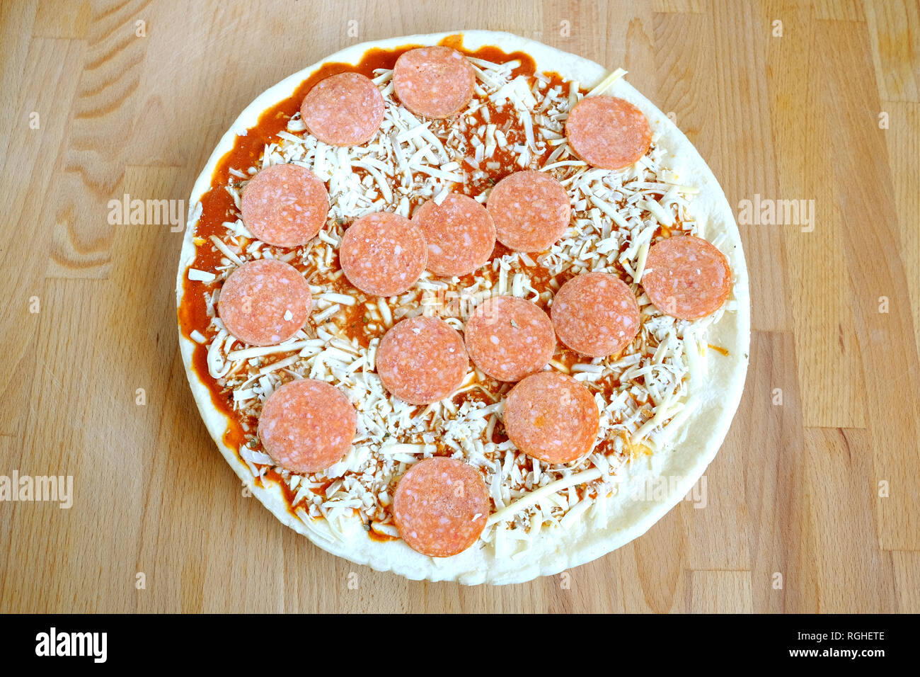 Materie (nella quasi totalità) impreparati pizza sul marrone sabbia cucina in legno table top view closeup Foto Stock