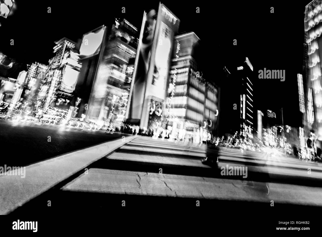 Pedoni di attraversare la strada nel cuore del quartiere di Ginza a Tokyo. Ginza attraversando la notte. Movimento sfocate, immagine in bianco e nero. Foto Stock