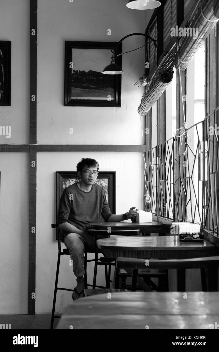 Solo l'uomo nella caffetteria in bianco e nero Foto Stock