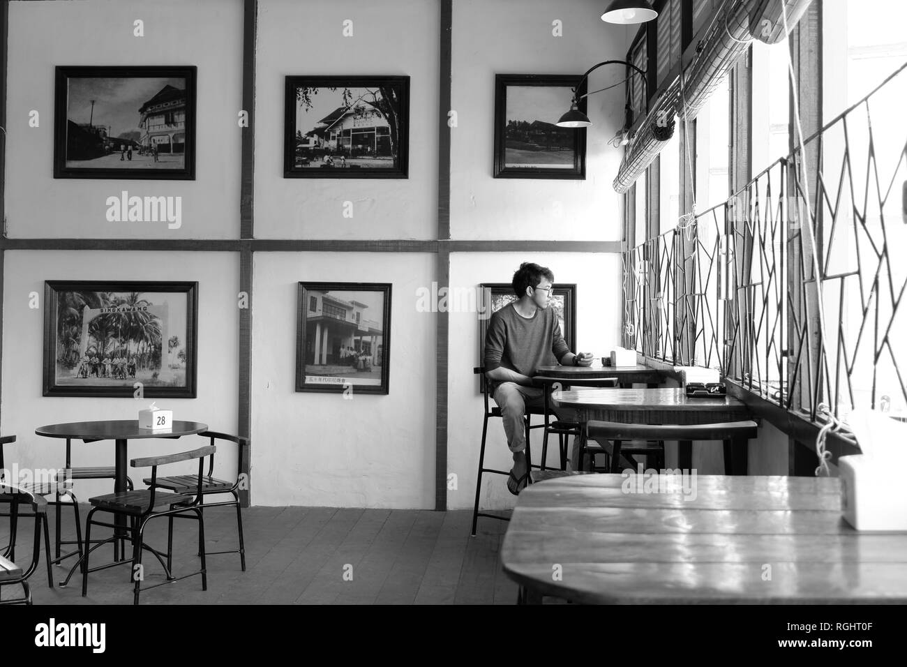 Solo l'uomo nella caffetteria in bianco e nero Foto Stock