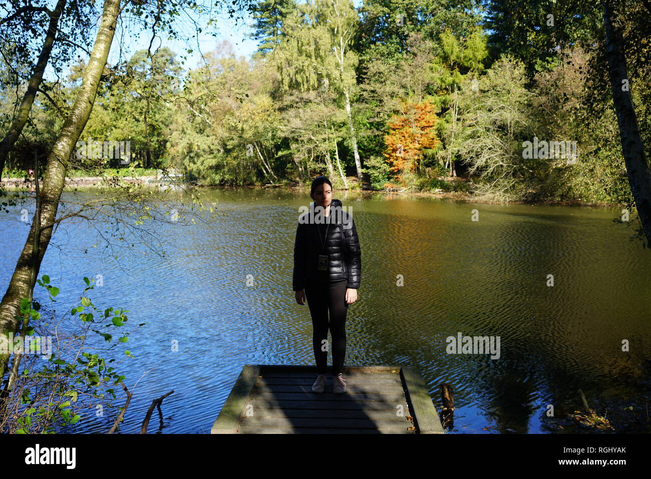 La donna in piedi di fronte ad un lago Foto Stock