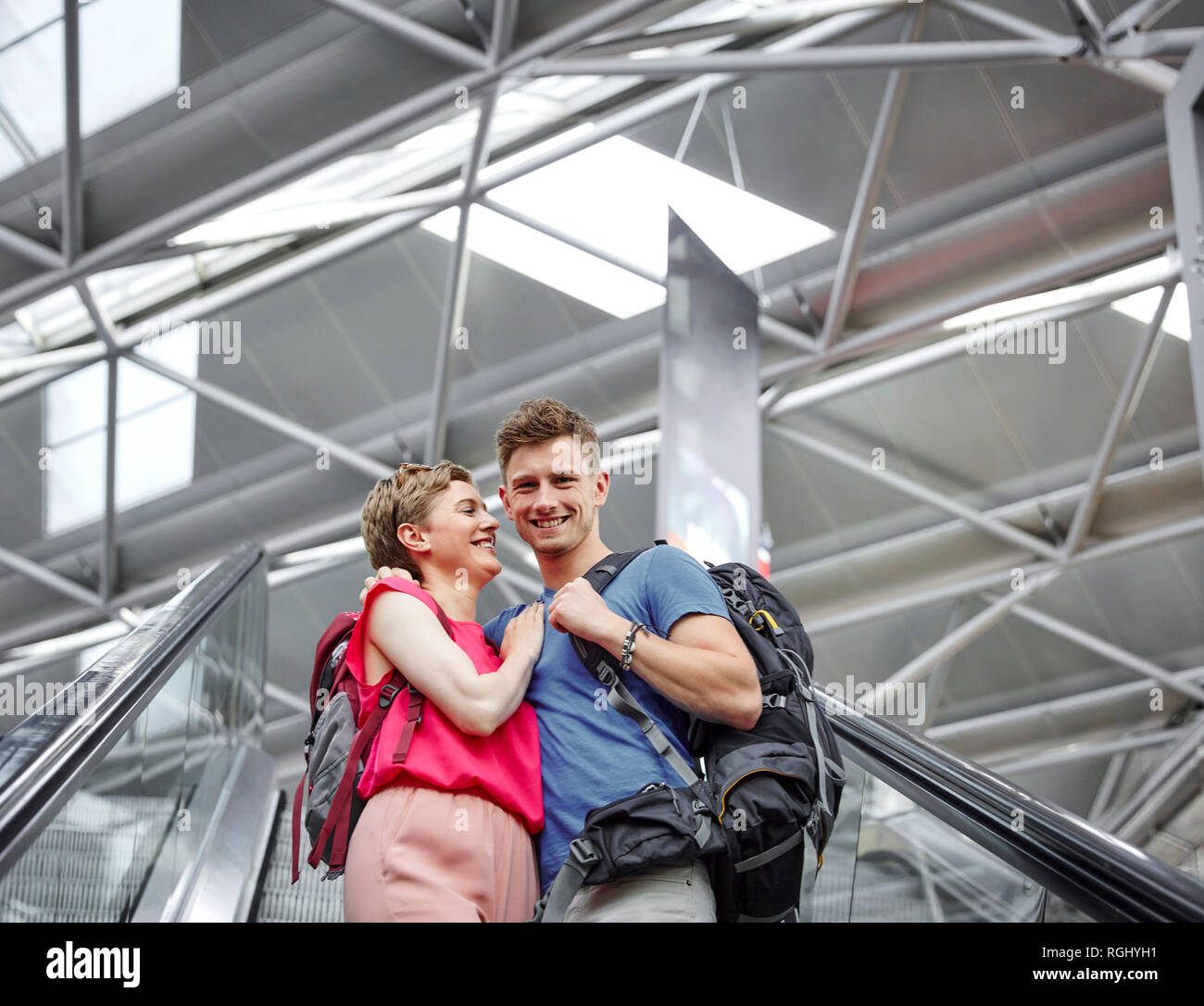 Coppia felice su escalator in aeroporto Foto Stock