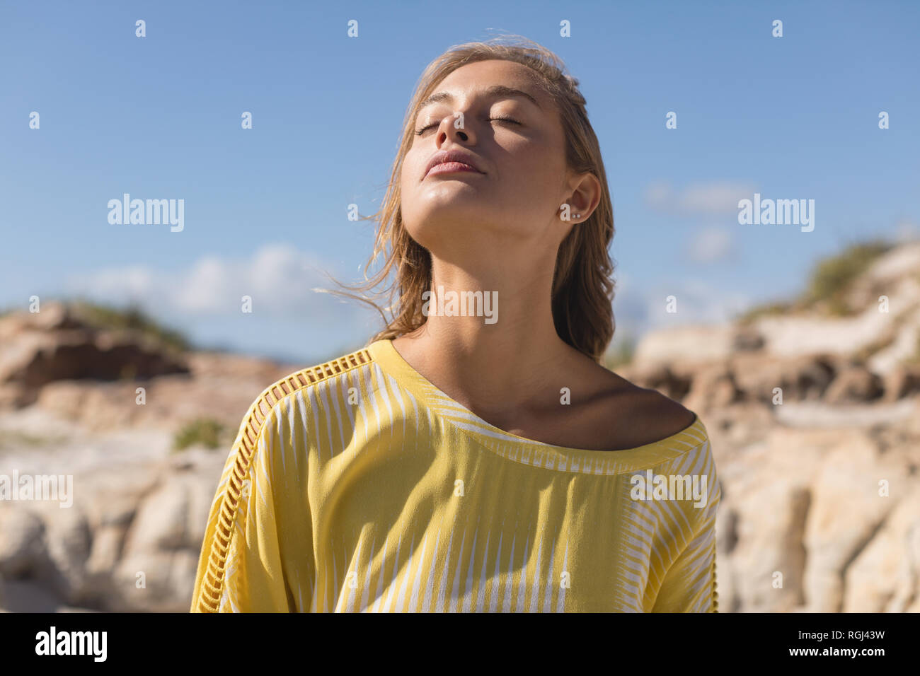 Bella donna in piedi con gli occhi chiusi a beach Foto Stock
