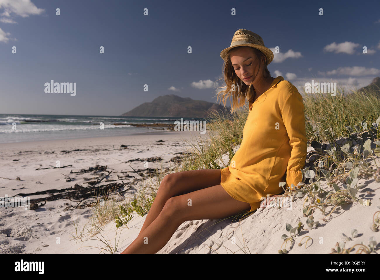 Donna in hat rilassante sulla spiaggia Foto Stock