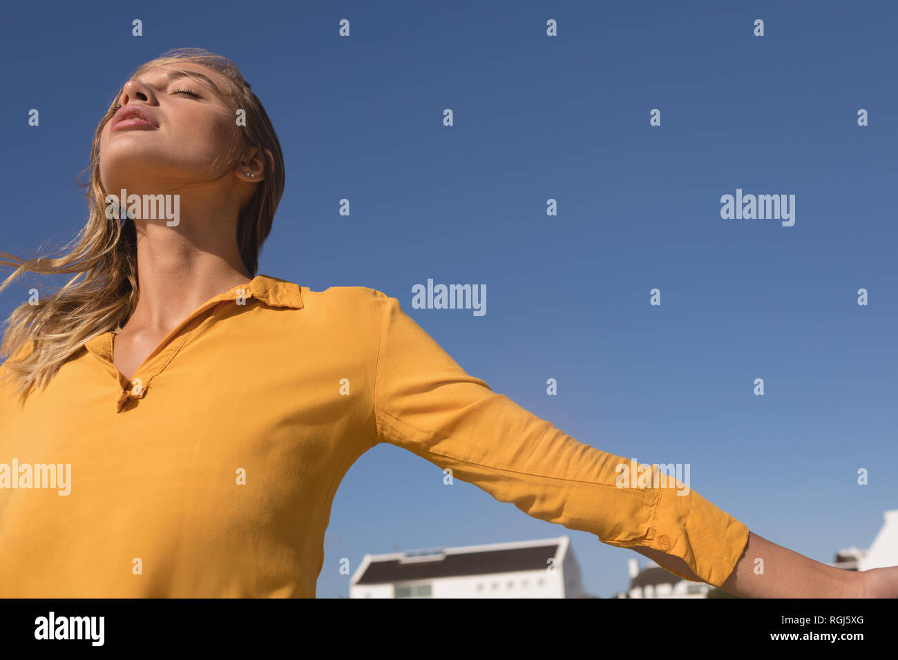 Donna in piedi con le braccia aperte sulla spiaggia Foto Stock