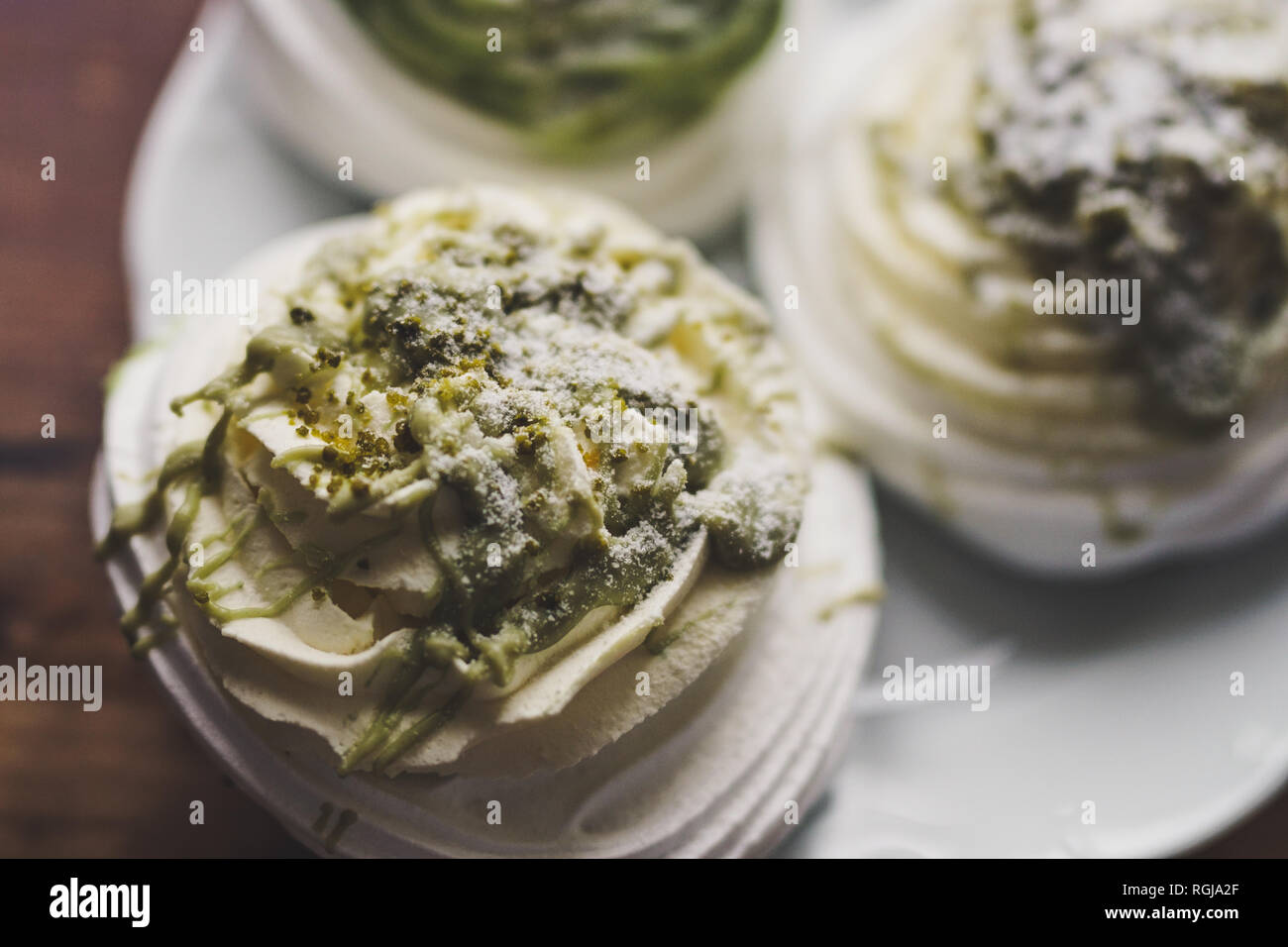 Pavlova tre torte con crema di pistacchio e la tazza di caffè Foto Stock