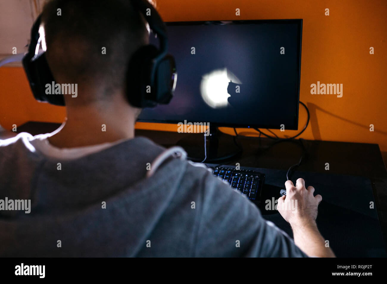 Giovane uomo seduto al PC, i giochi per computer Foto Stock