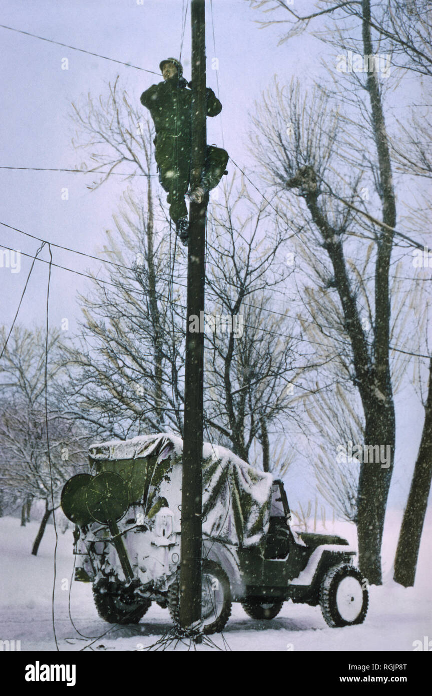 Signal Corps Lineman riparazione danneggiato linee telefoniche, Ardennes-Alsace Campagna, Battaglia di Bulge, 1945 Foto Stock