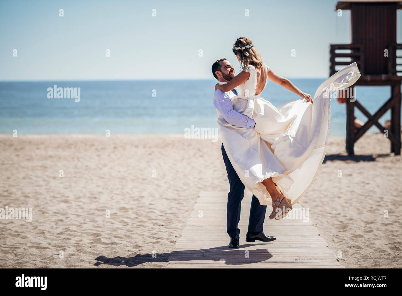 Felice coppia di sposi godendo il loro giorno di nozze sulla spiaggia Foto Stock