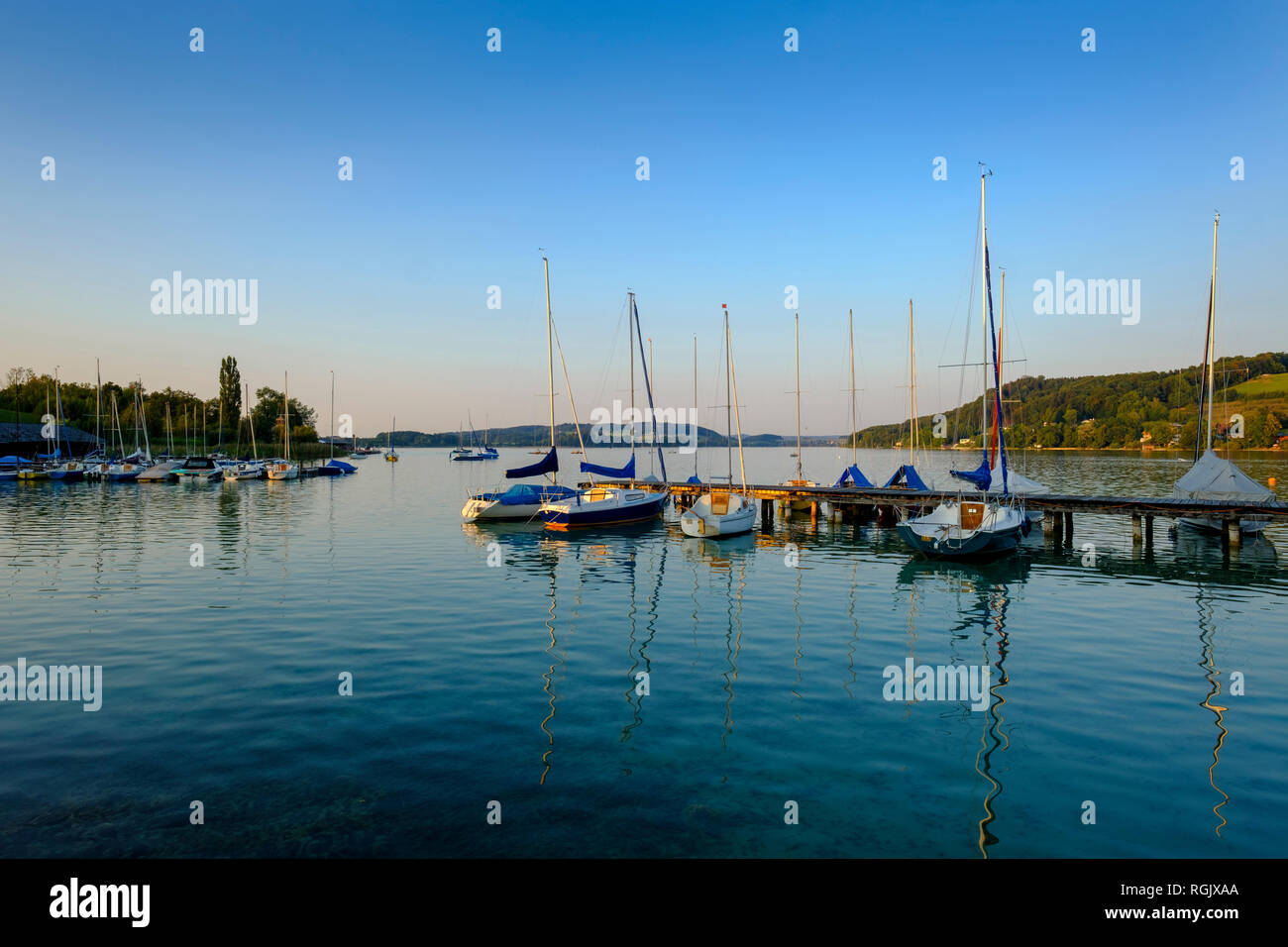 Austria, Land Salzburg, Flachgau, Mattsee, il lago e le barche a vela di sera Foto Stock