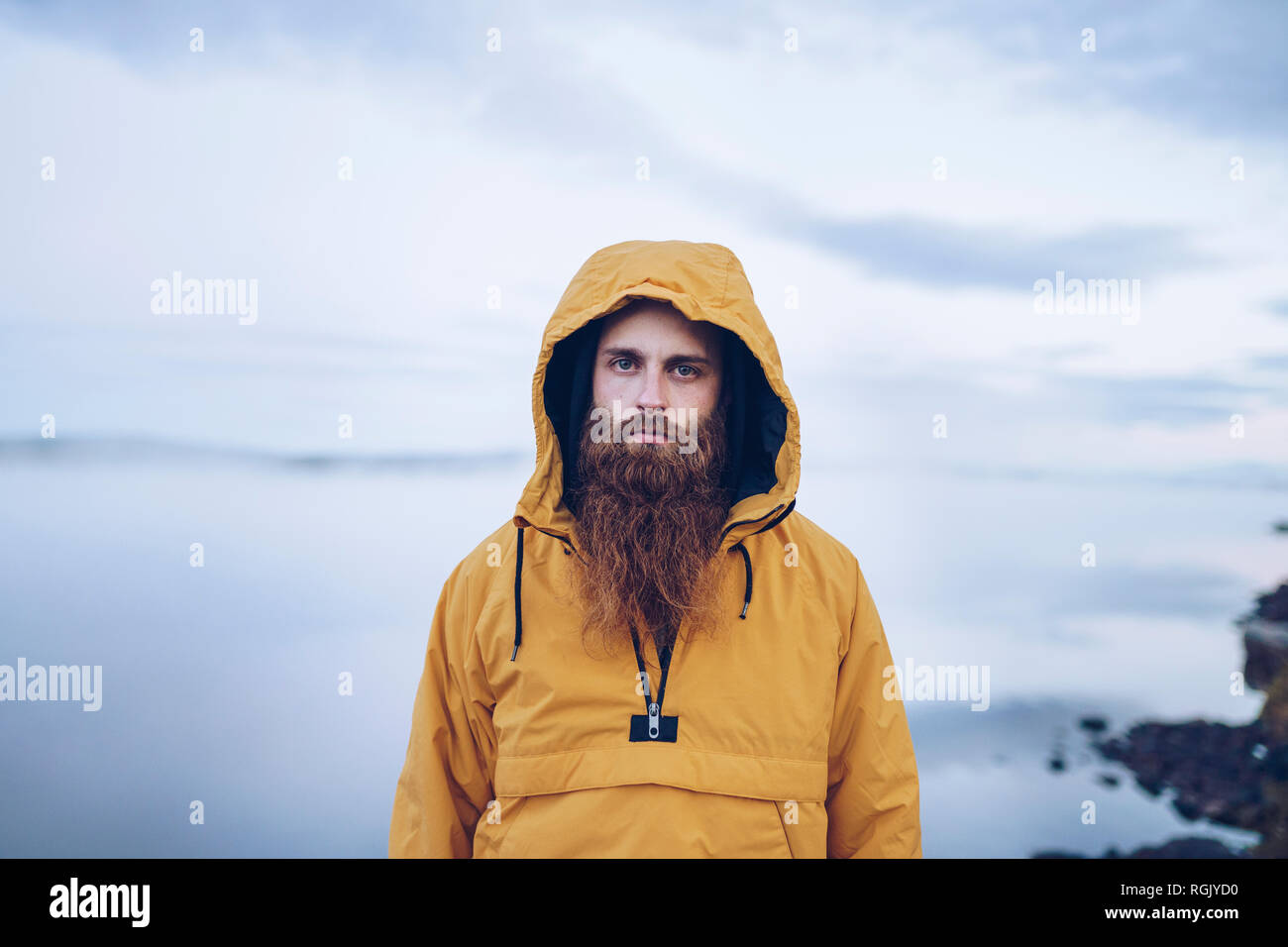 La Svezia, Lapponia, ritratto di grave uomo con barba folta indossando giacca a vento giallo Foto Stock