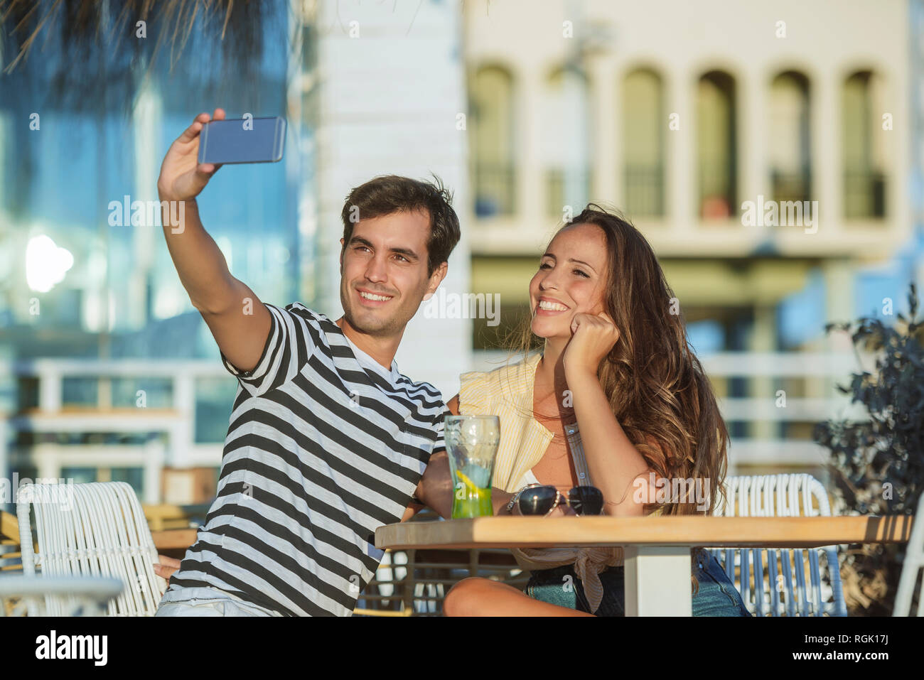 Felice coppia giovane prendendo un selfie sulla terrazza di un bar Foto Stock