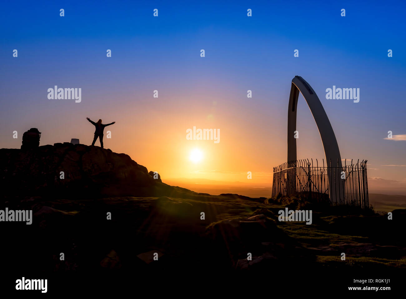 Gran Bretagna, Scozia, East Lothian, North Berwick, North Berwick diritto, whale osso mandibolare arch, tramonto, turista femminile con i bracci sollevati Foto Stock