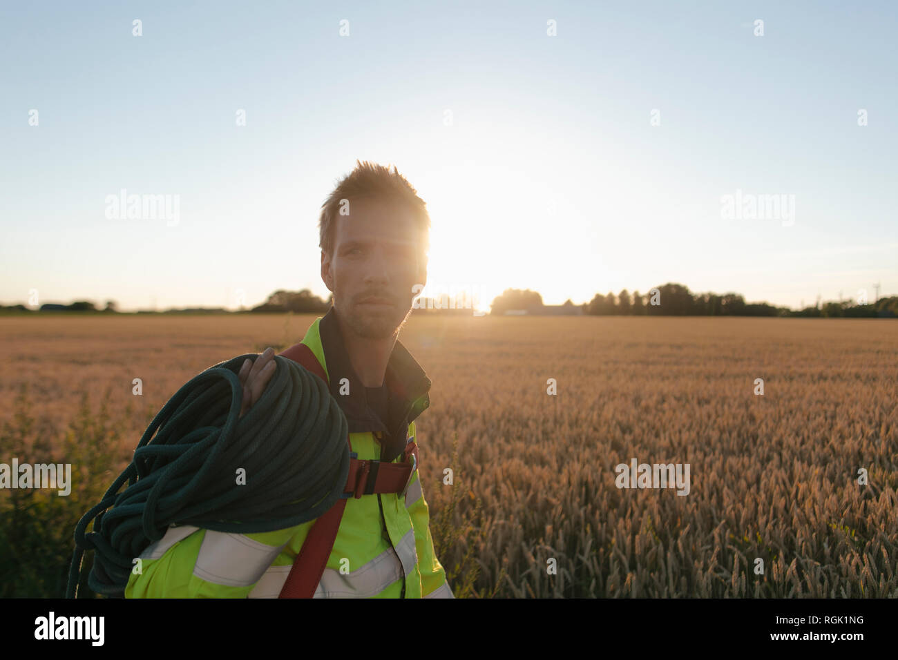 Tecnico di arrampicata attrezzature a un campo in sunset Foto Stock