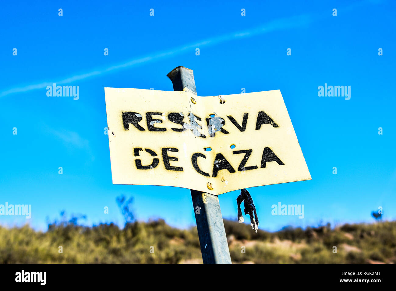 Riserva di caccia segnale in Spagna. Giornata di sole. Leaky e metallo arrugginito piastra. Cielo blu Foto Stock