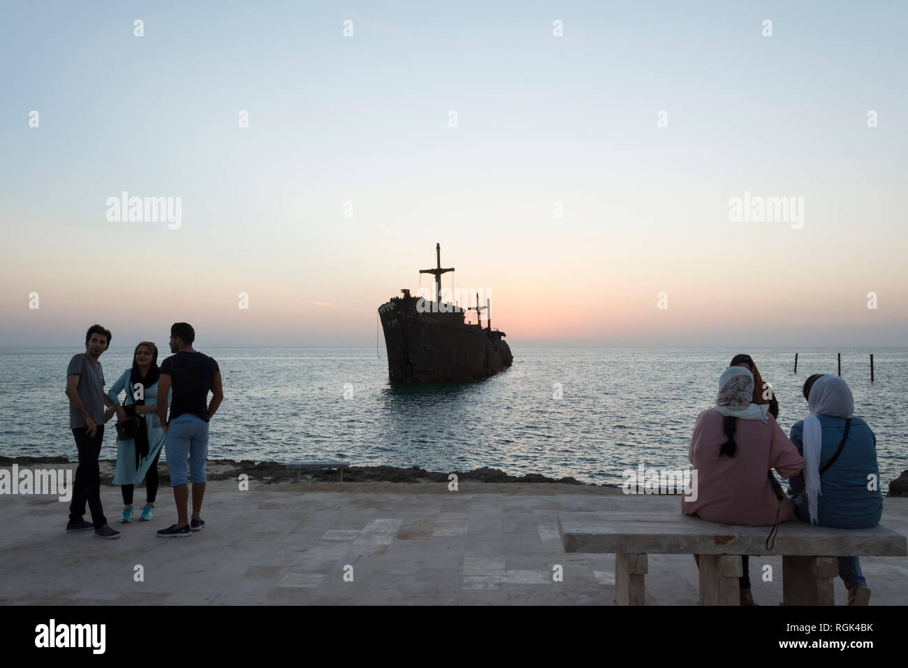 Kish Island, IRAN - 31 ottobre 2015 persone che visitano e scattare foto con nave greca relitto in kish island dopo il tramonto Foto Stock
