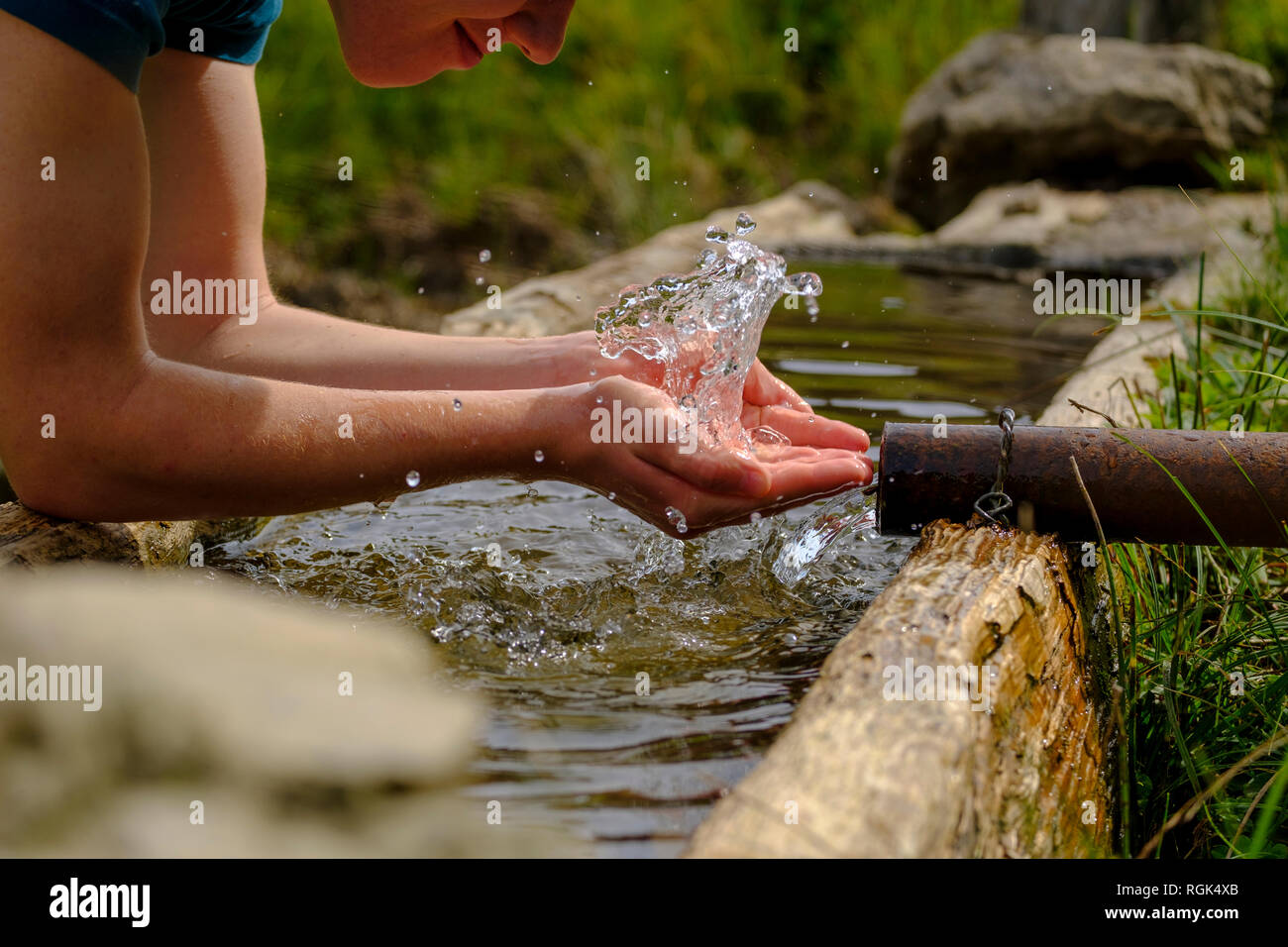 In Germania, in Baviera, Chiemgau, giovane rinfrescante presso una fontana Foto Stock