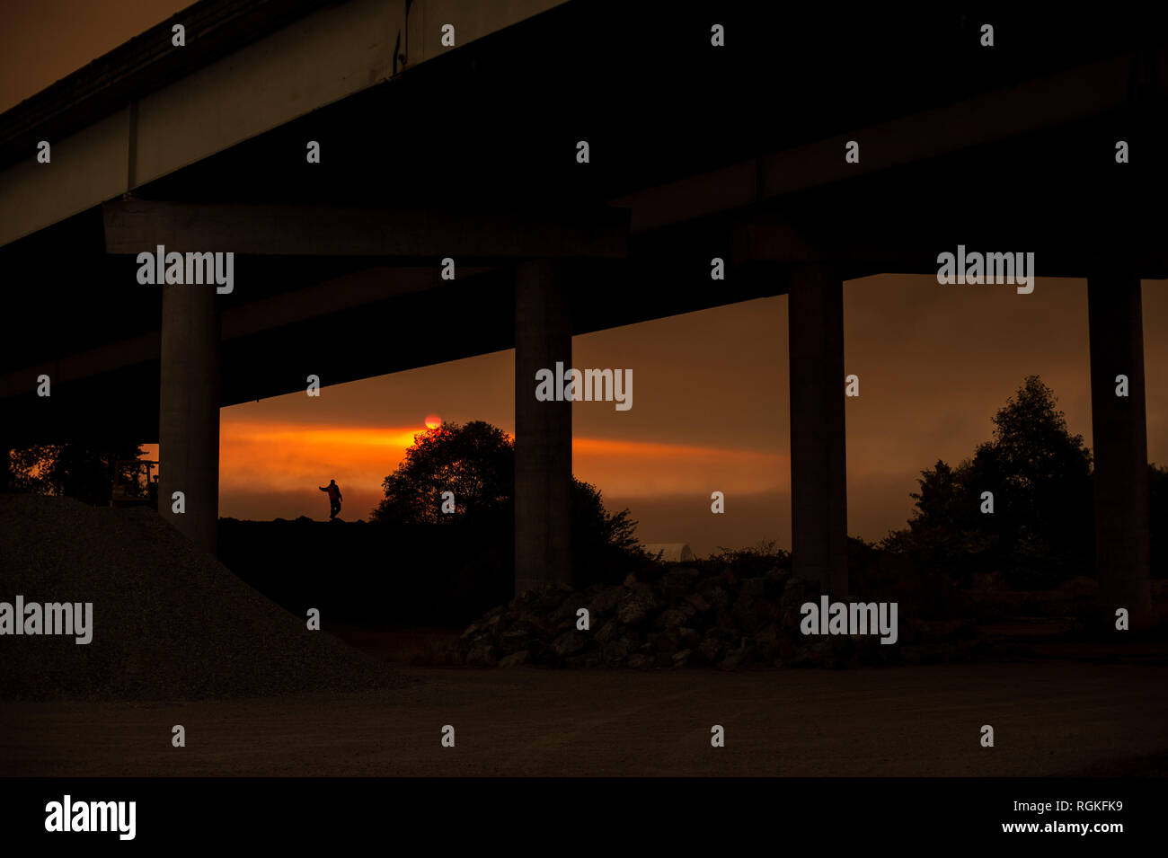 Stagliano uomo sotto l'autostrada cavalcavia al sito in costruzione. Foto Stock