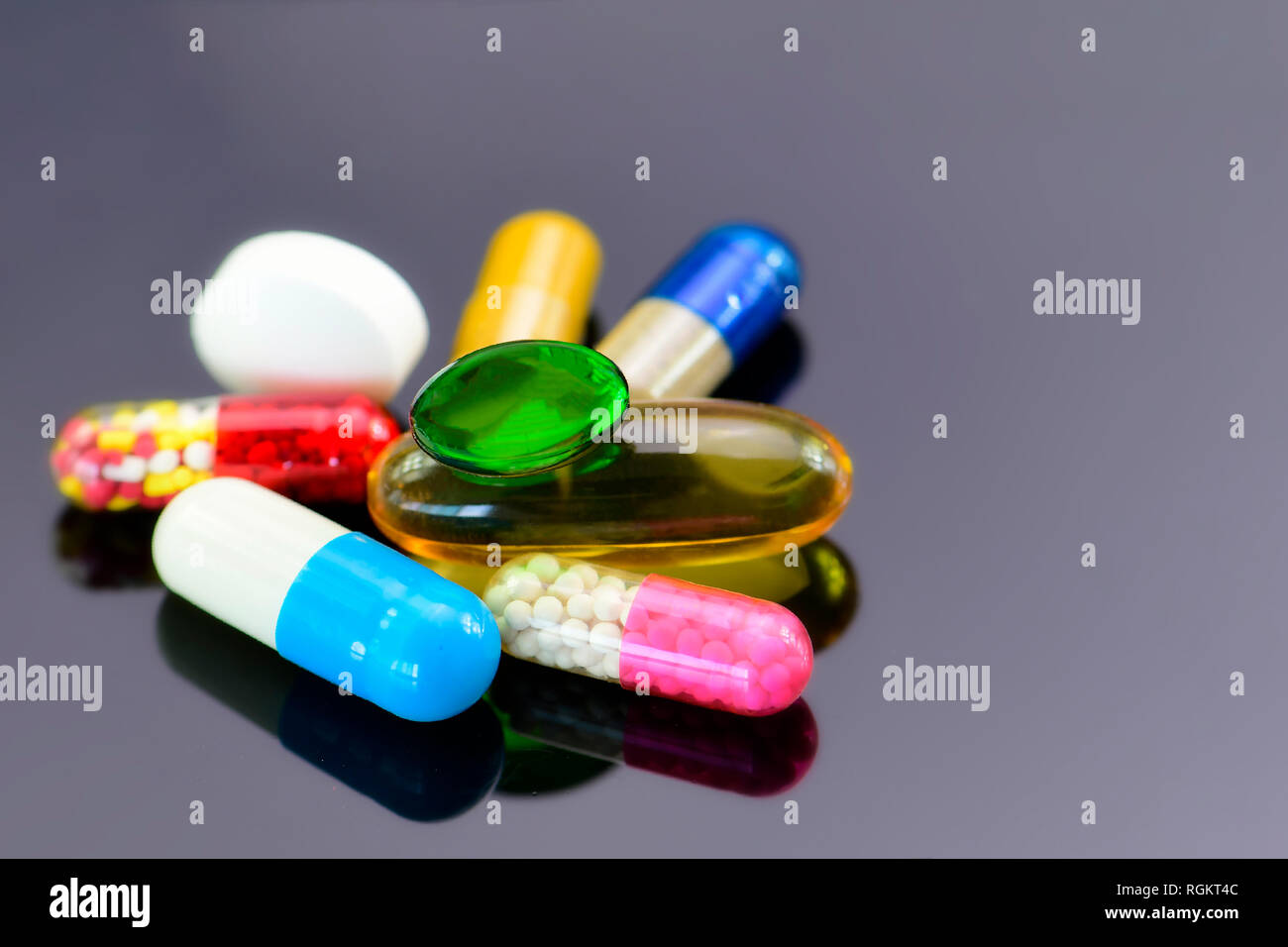 Colorato di medicazioni orali su sfondo scuro. Capsule e compresse per via orale sotto forma di dosaggio. Foto Stock
