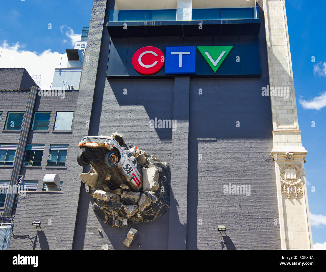 Scultura di news carrello la rottura della parete, CTV Città (TV) edificio (1913), Queen Street West, Toronto, Ontario, Canada Foto Stock