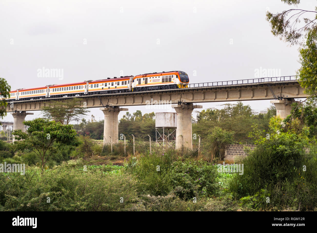 Il Madaraka Express il servizio passeggeri di treno che viaggia su un viadotto di sezione di Nairobi per Mombasa Ferrovia SGR, Athi River, Kenya Foto Stock