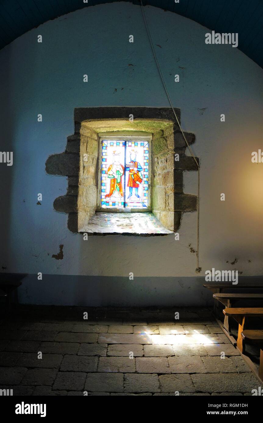 La luce del sole spiata attraverso una finestra di vetro colorato nella storica chiesa di San Cado Bretagna Francia Foto Stock