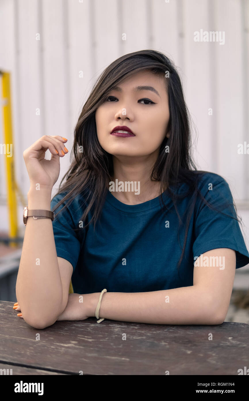 Giovane ragazza in posa per la telecamera in prossimità di una struttura urbana. Foto Stock