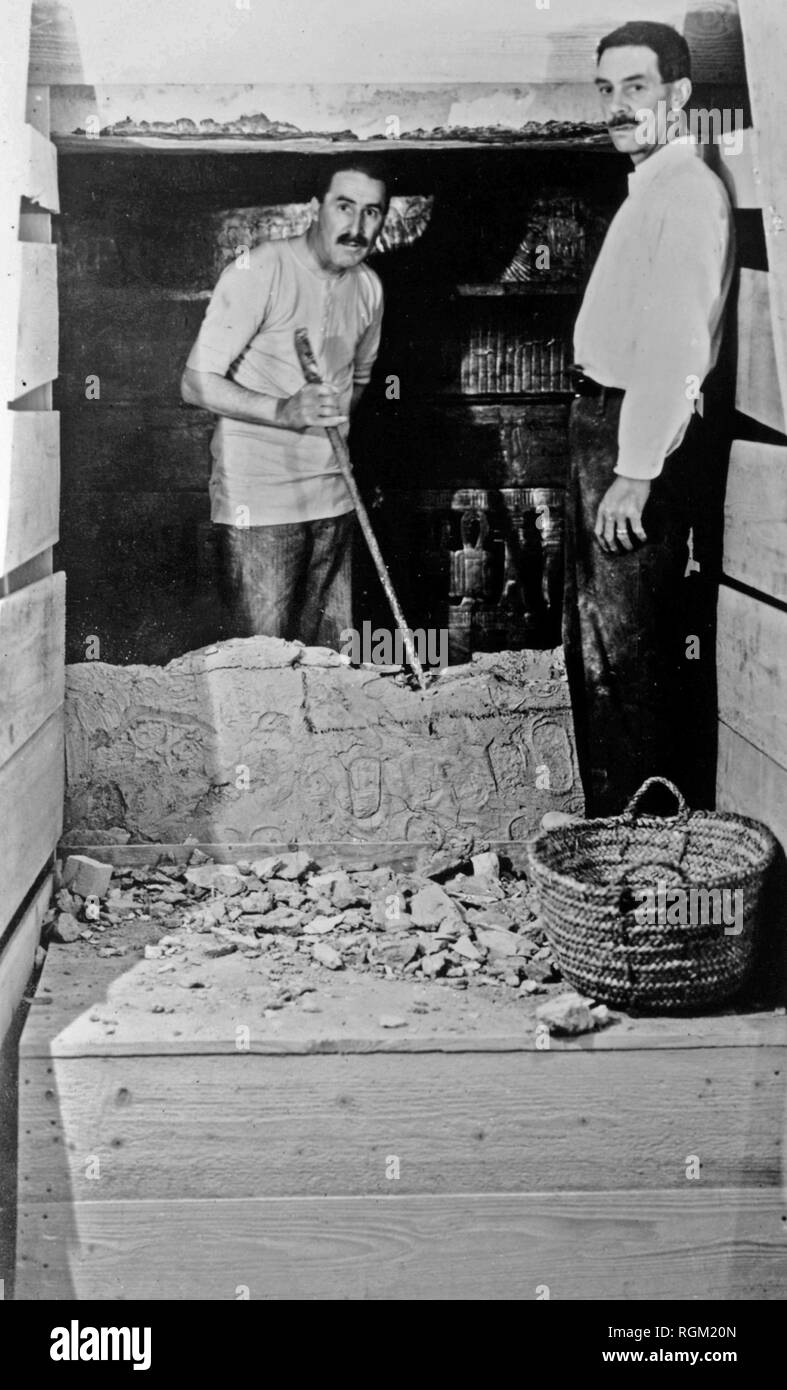 Howard Carter che ha scoperto Tutankhamon la tomba nella Valle dei Re di Luxor in Egitto. Novembre 1922. In apertura del re Tutankhamon la tomba durante l'entrata in camera sigillata con Howard Carter (sinistra) all'interno e l'A.C. Macis (destra) al di fuori del muro rotto. Scansionata da materiale di immagine negli archivi della stampa Ritratto - Servizio (ex premere ritratto Bureau). Foto Stock