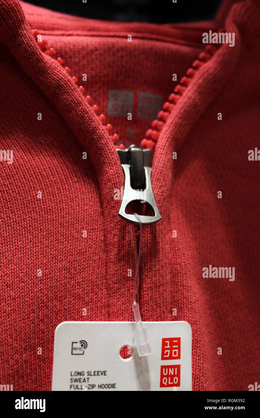 T-shirt rossa visualizzata in Uniqlo store, close-up Foto Stock