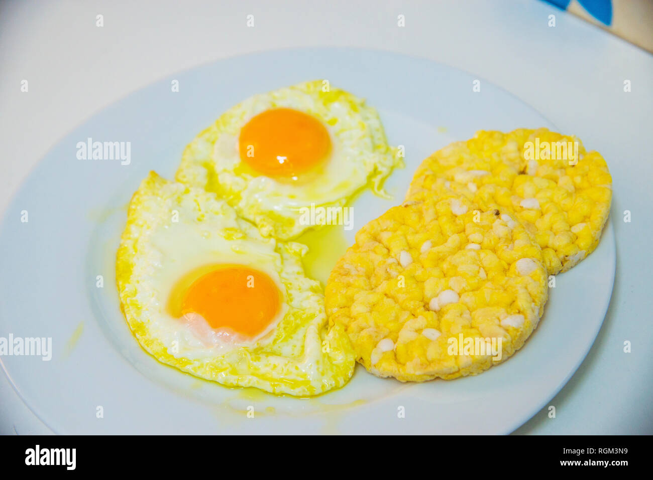 Due uova fritte con frittelle di mais. Foto Stock