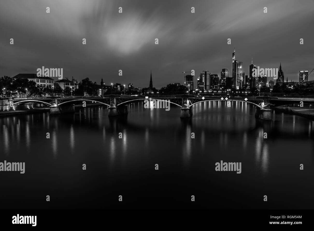 Luci della città e rainclouds riflettendo su Flosserbrücke in Frankfurt am Main di notte Foto Stock