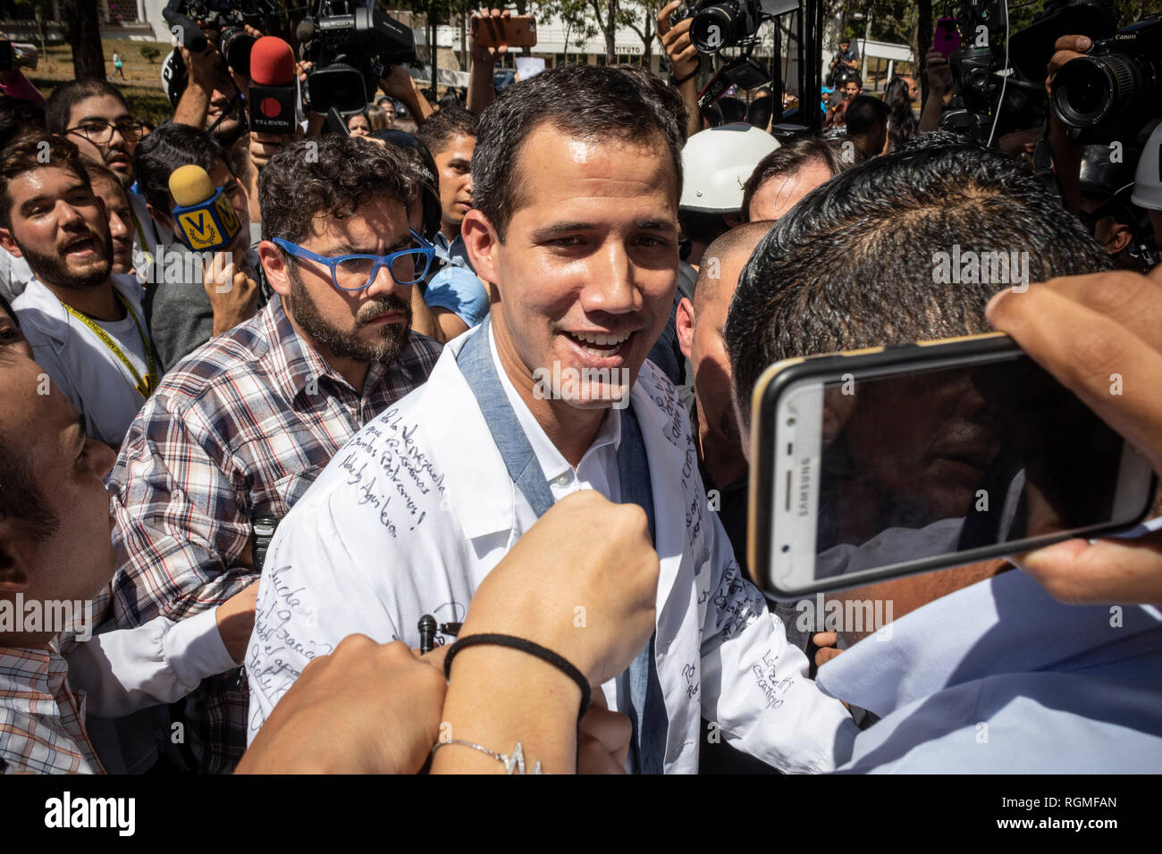 Caracas, Venezuela. 30 gen, 2019. Juan Guaido (M), l'auto-proclamato presidente ad interim, marche contro il governo del presidente Maduro in camice bianco con il personale sanitario e i medici e studenti di medicina. In mezzo alla lotta di potere tra il governo e l'opposizione, dimostranti contro il controverso capo di stato Maduro hanno nuovamente preso per le strade in Venezuela. Credito: Rayneri Pena/dpa/Alamy Live News Foto Stock
