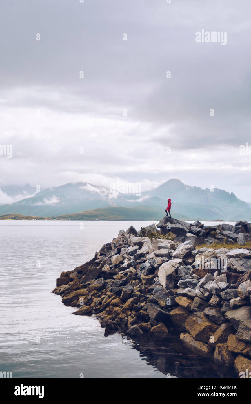 Norvegia, Senja, uomo in piedi sulla roccia presso la costa Foto Stock