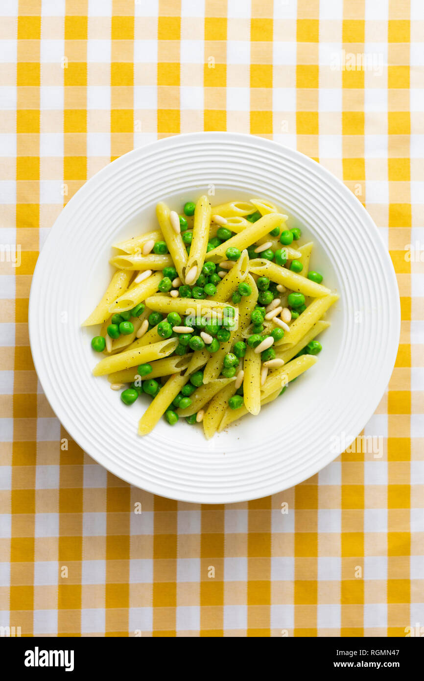 Penne con piselli e pinoli su piastra, dal di sopra Foto Stock