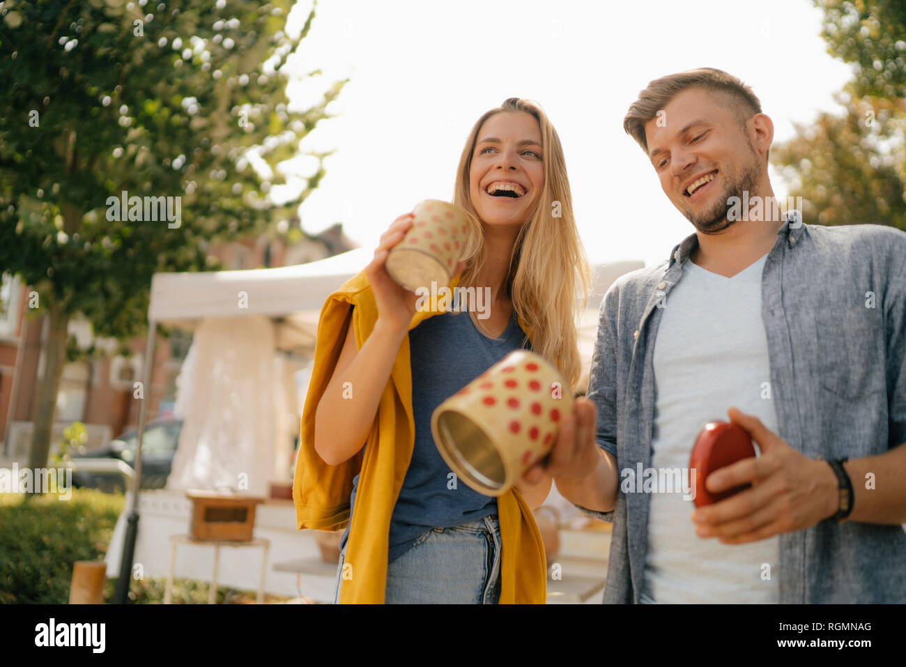 Belgio, Tongeren, felice coppia giovane con le lattine di alluminio su un antico mercato delle pulci Foto Stock