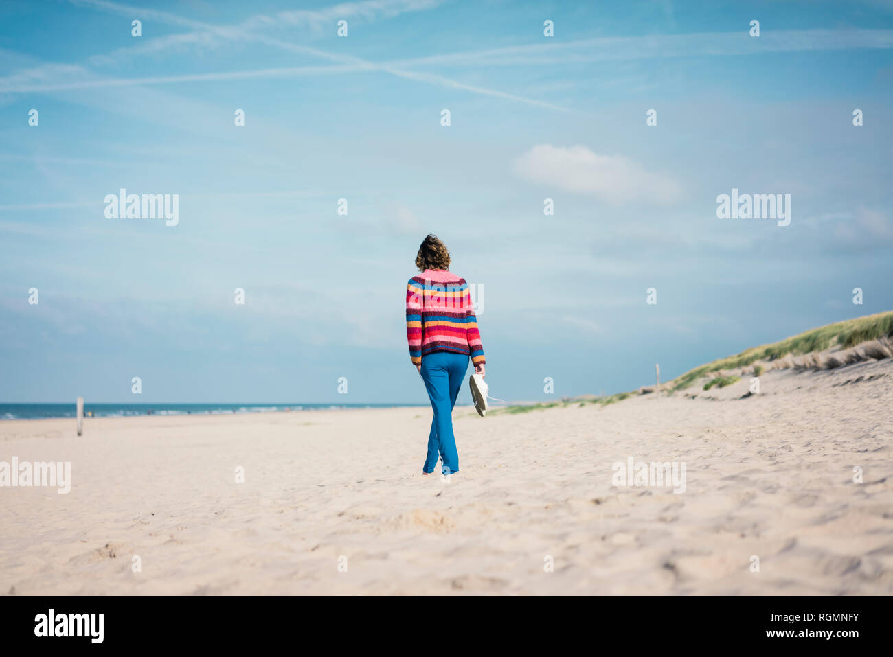 Donna matura correre a piedi nudi sulla spiaggia Foto Stock